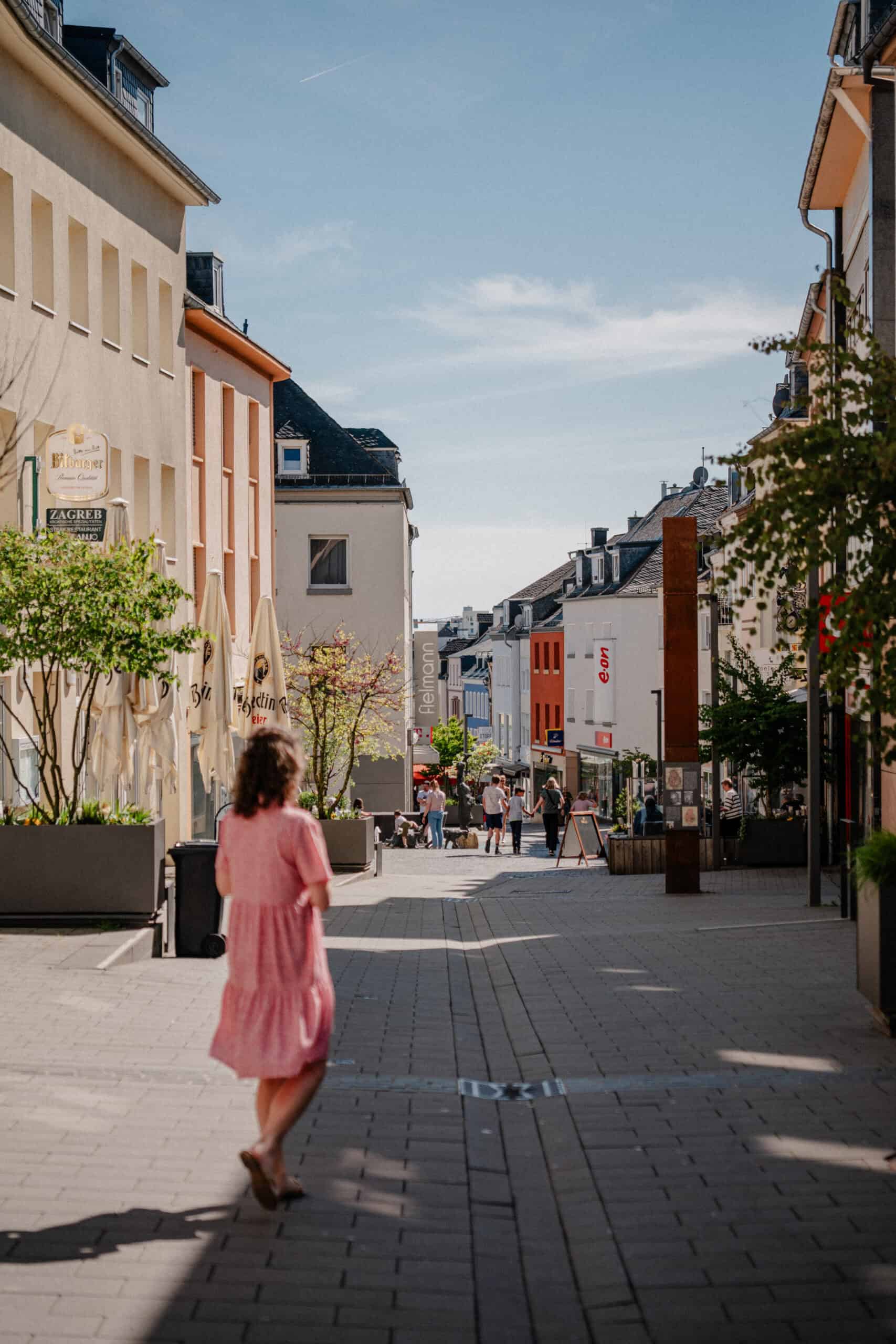 Farbige Mosaikfliesen an der Mosaikkirche in Bitburg, moderne Architektur, urbane Umgebung, beliebte Touristenattraktion, Blick auf die Fußgängerzone, lebendige Stadtmitte, kulturelle Sehenswürdigkeit, Stadtansicht.